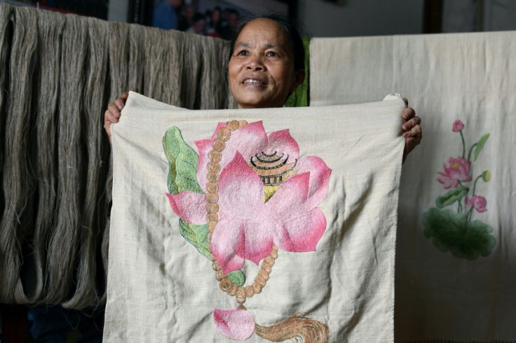 Phan Thi Thuan poses with with a hand-made scarf she made from lotus "silk" at her workshop in Hanoi