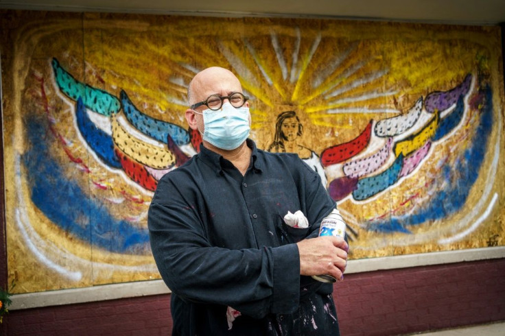 Dirk Ingram poses in front of the mural decorating his massage studio