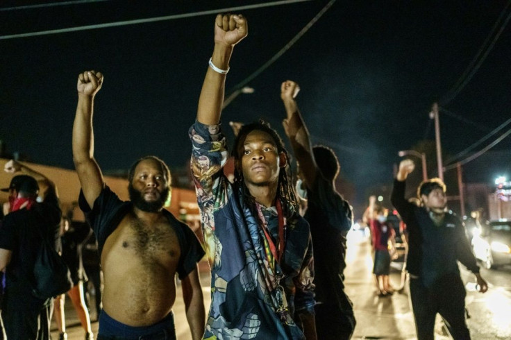 Protesters raise their fists during a demonstration against the shooting of Jacob Blake in Kenosha, Wisconsin