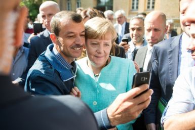 An asylum seeker takes a selfie with German Chancellor Angela Merkel, in Berlin on September 10, 2015 at the beginning of Europe's migrant crisis