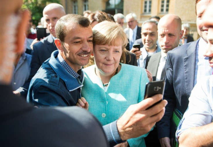 An asylum seeker takes a selfie with German Chancellor Angela Merkel, in Berlin on September 10, 2015 at the beginning of Europe's migrant crisis