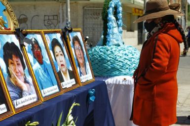 A woman looks at photos of health workers in Puno, Peru who died from Covid-19