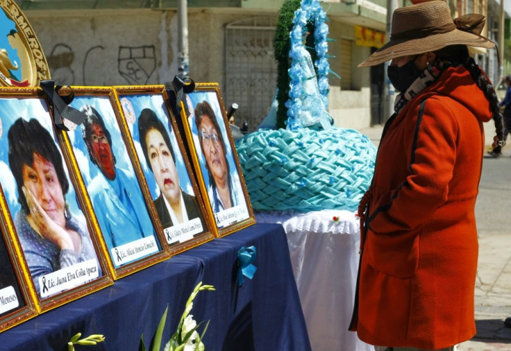 A woman looks at photos of health workers in Puno, Peru who died from Covid-19