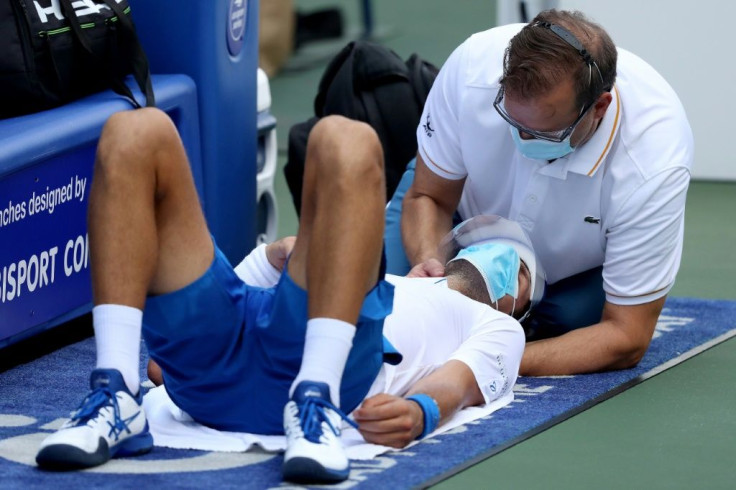 World number one Novak Djokovic received neck treatment from ATP trainer Clay Sniteman, right, but managed to outlast Roberto Bautista Agut in an ATP Western and Southern Open semi-final Friday