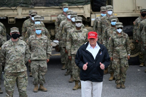 US President Donald Trump poses with National Guard troops in Lake Charles, Louisiana, on August 29, 2020 on a trip to survey damage from Hurricane Laura