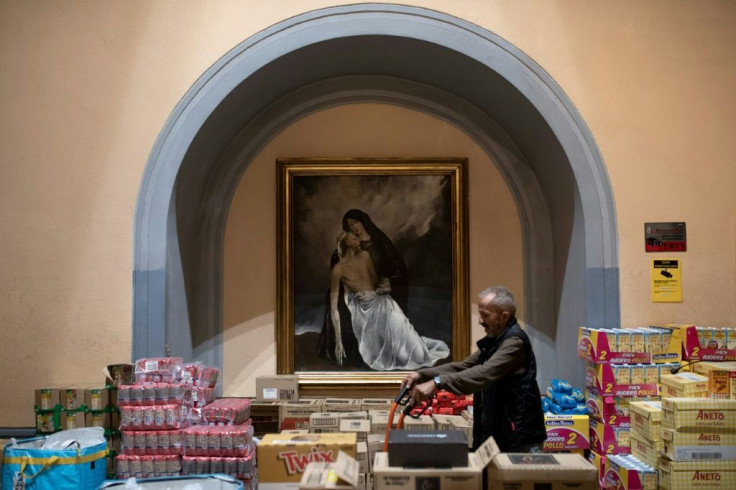 A volunteer prepares rations of donated food at Santa Anna church in Barcelona. Spain is struggling to cope with an avalanche of applications for its minimum basic income scheme