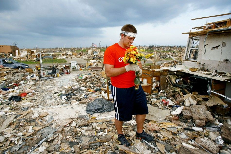 Volunteer Nelson Rumsey, of Quincy, Il., collects plastic flowers from a house destroyed by the May 22 tornado in Joplin