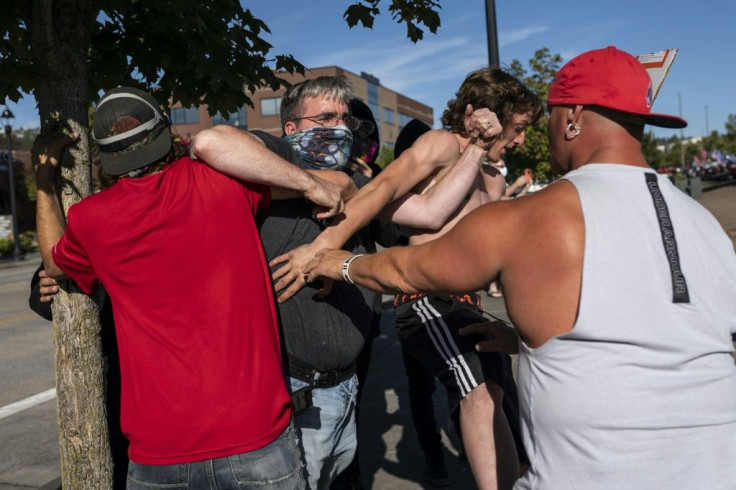 A Black Lives Matter protester scuffles with attendees of a pro-Trump rally