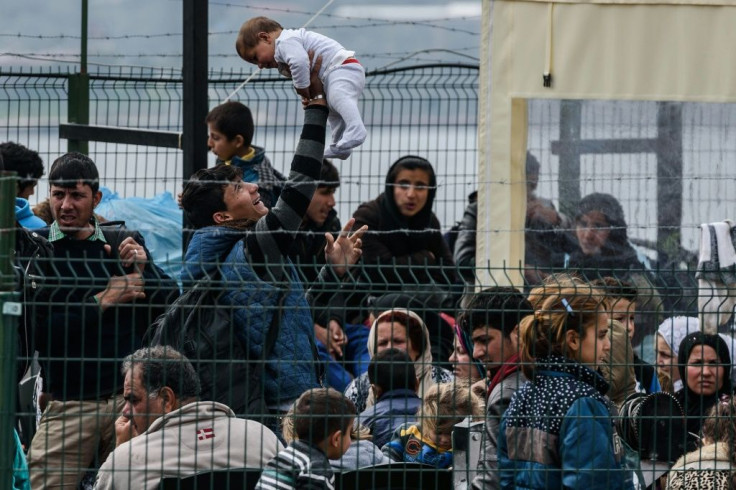 Migrants wait at a Turkish coastguard post in Izmir on March 20, 2016, after being caught trying to reach Greece by sea