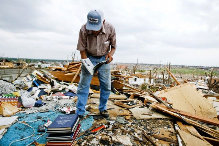 Hugh Hills salvages books from the upper level of his house which was destroyed in the May 22 tornado in Joplin
