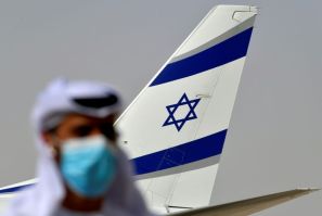 An Emirati official stands near the El Al aircraft which carried a US-Israeli delegation to the UAE on the first ever direct commercial flight following their normalisation accord