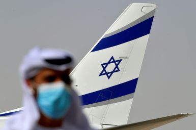 An Emirati official stands near the El Al aircraft which carried a US-Israeli delegation to the UAE on the first ever direct commercial flight following their normalisation accord