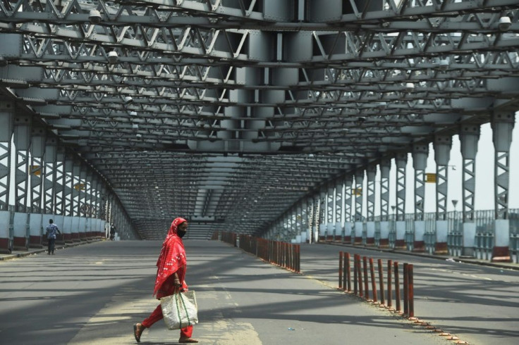 A commuter walks past the deserted Howrah Bridge during a day-long state-imposed lockdown as a preventive measure against the surge in Covid-19 cases in Kolkata, India