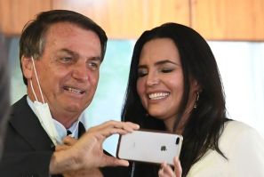 Analysts say the downturn has been mitigated by a stimulus package decided on by the government of Brazilian President Jair Bolsonaro, shown here posing with a doctor before the event "Brazil beating COVID-19" at Planalto Palace on August 24, 2020