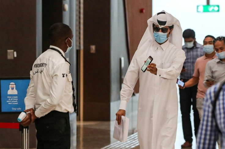 A passenger boarding the Doha metro shows a security guard his phone with the contact-tracing app indicating the all-clear from coronavirus