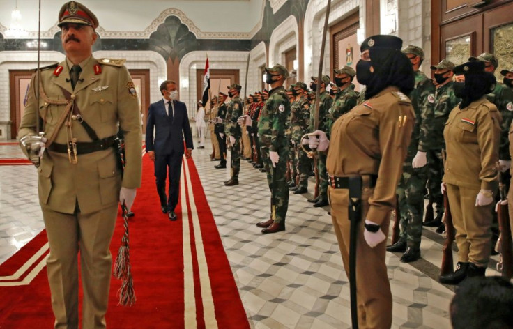 French President Emmanuel Macron, mask-clad due to the coronavirus pandemic, arrives for a meeting with Iraq's Prime Minister Mustafa al-Kadhimi