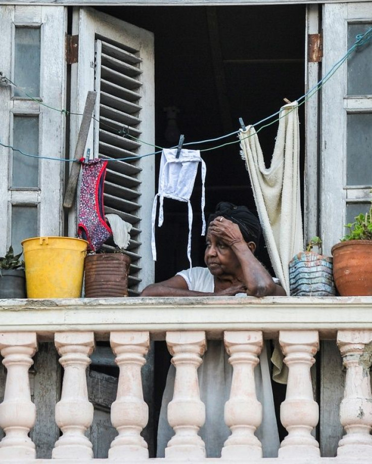 A woman looks out from her balcony in Havana as a 15-day dusk-to-dawn curfew comes into force on September 1, 2020