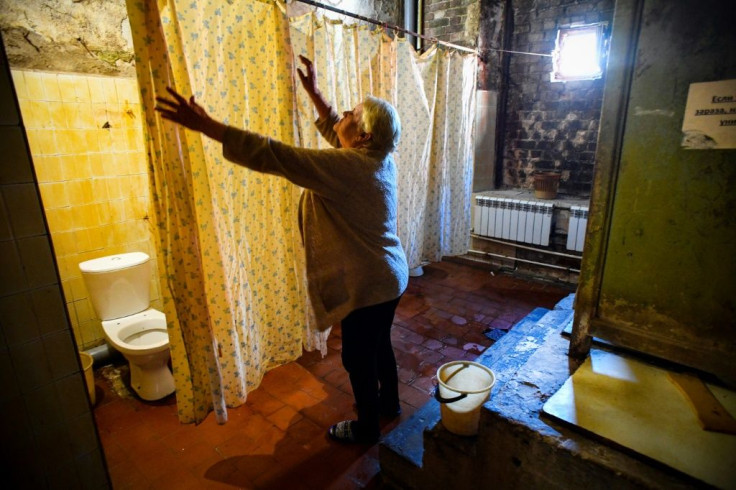 Residents share communal toilets, separated by shower curtains, and the ceilings are black with mould