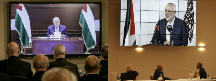 Palestinian factions gathered at their embassy in Beirut attend by video conference talks with president Mahmud Abbas (screen), while their counterparts in the West Bank watch speech of Hamas chief Ismail Haniyeh in Beirut