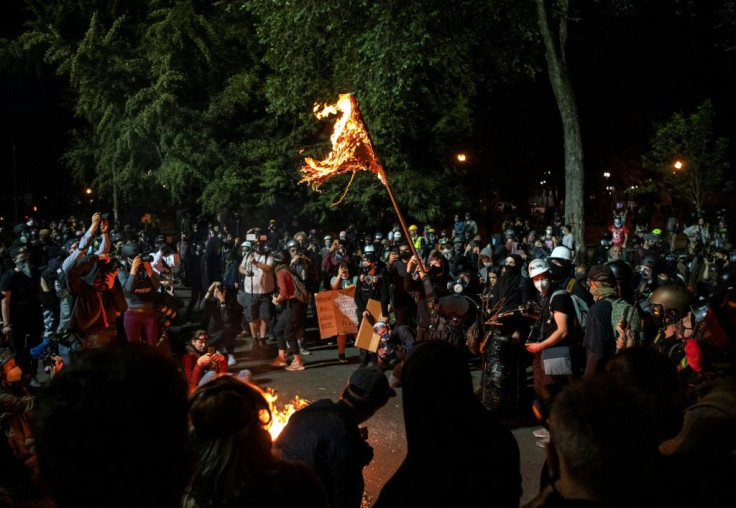 A demonstrator burns an American flag outside the Mark O Hatfield United States Courthouse on July 31, 2020 in Portland, Oregon