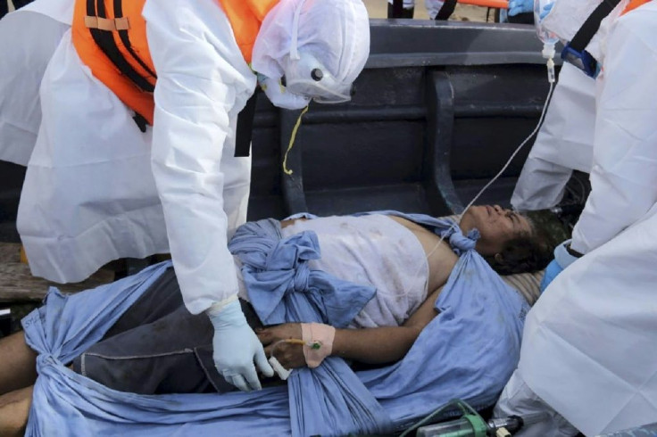 Sri Lankan navy officers carry an injured crewman from the stricken oil tanker, the New Diamond