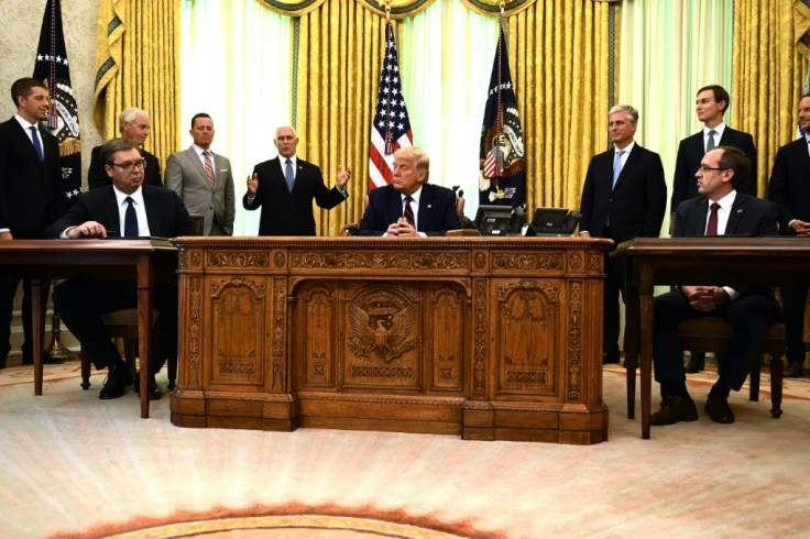 US President Donald Trump (C), Kosovar Prime Minister Avdullah Hoti (R) and Serbian President Aleksandar Vucic (L) listen to US Vice President Mike Pence during a signing ceremony, in the Oval Office of the White House in Washington, DC, on September 4, 2