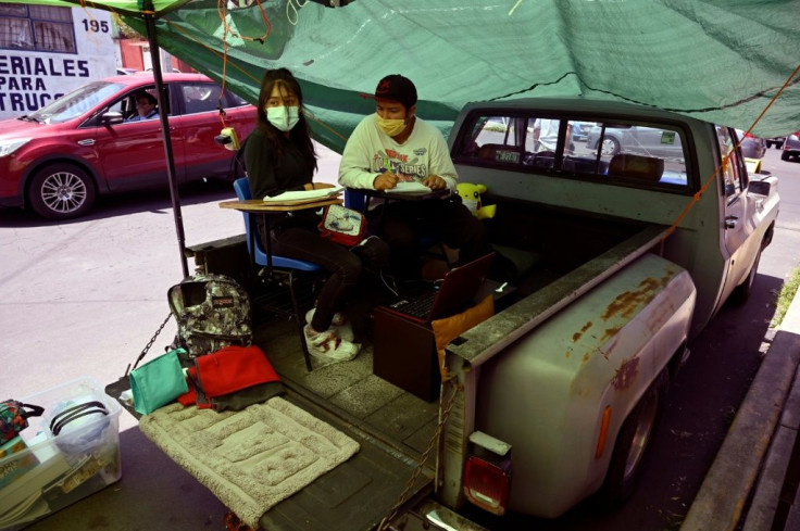 The back of a pick-up truck is one of the unusual locations for improvised classrooms at a street school in the Mexican capital