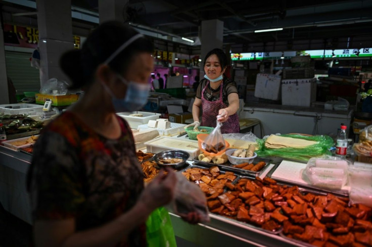 Yi Xinhua says sales at her stall in a Wuhan wet market are only half of the pre-pandemic level