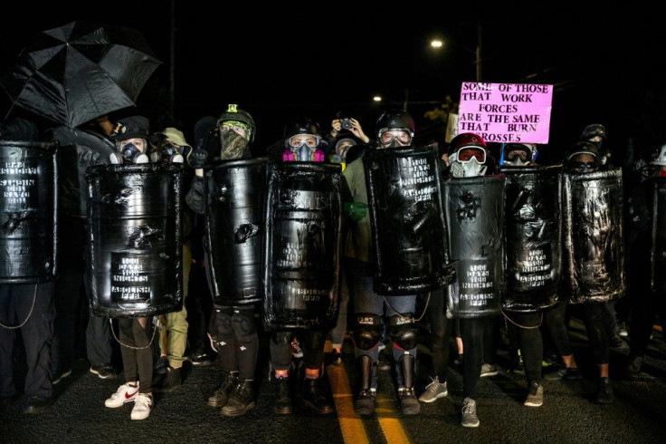Protestors wearing gas masks and carrying homemade shields demonstrate in Portland, Oregon