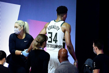 Milawukee star Giannis Antetokounmpo gingerly leaves the court after re-injuring his right ankle in the first half of the Bucks' must-win NBA playoff series game four against the Miami Heat