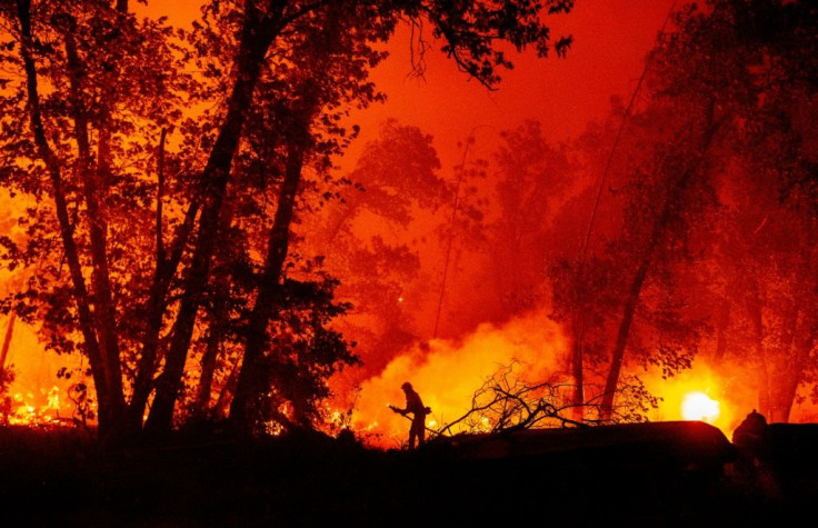 A firefighter douses flames as they push towards homes during the Creek Fire in the Cascadel Woods area of unincorporated Madera County, California on September 7, 2020