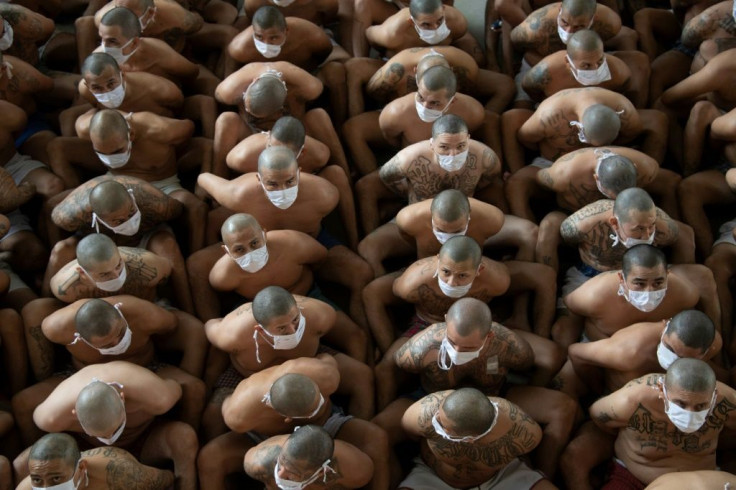 Members of the MS-13 and Mara 18 gangs sit on the floor during a search operation at the Izalco maximum security prison in El Salvador