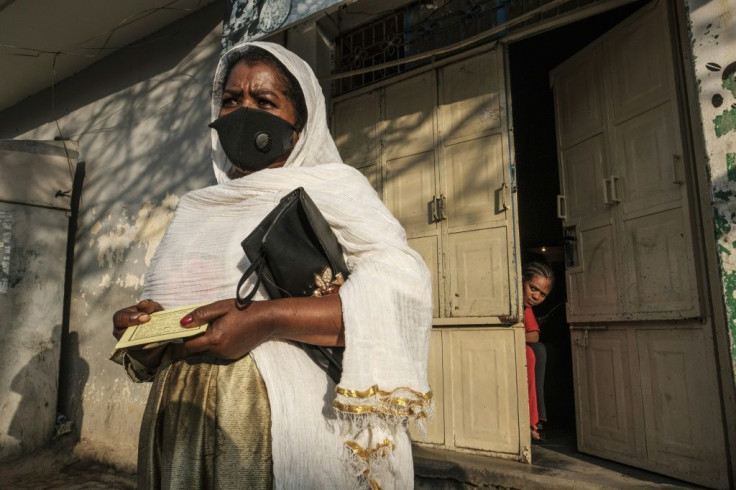 A woman holds a voting card as she waits in order to enter a polling station during Tigrayâs regional elections.