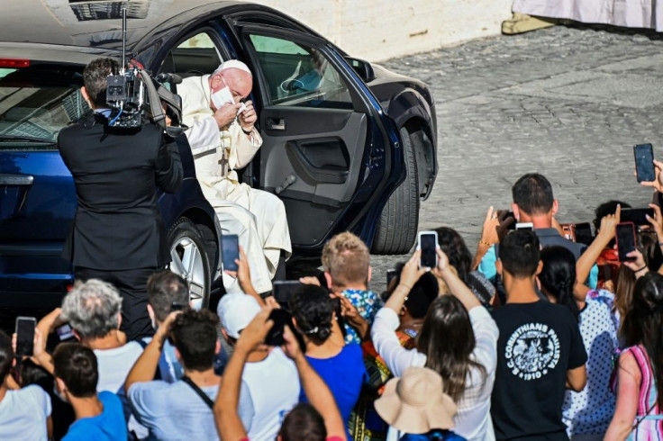 Pope Francis quickly removed his face mask as he emerged from his car