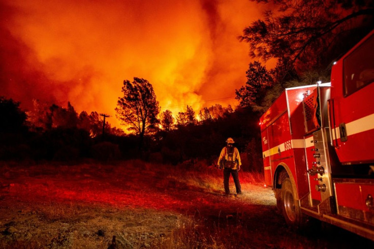 Butte County firefighters watch as flames tower over their truck at the Bear fire in Oroville, California