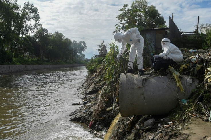 Researchers in Nepal collect samples of sewage dumped into a river to trace the coronavirus spread