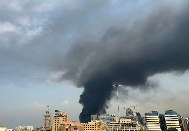 A huge column of black smoke billows into the sky over Beirut as the city's port is again engulfed by fire just weeks after a devastating dockside explosion