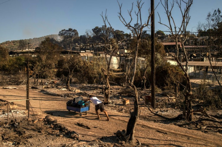 Where the camp's containers once stood, warped tent frames stick out of the rubble like charred skeletons