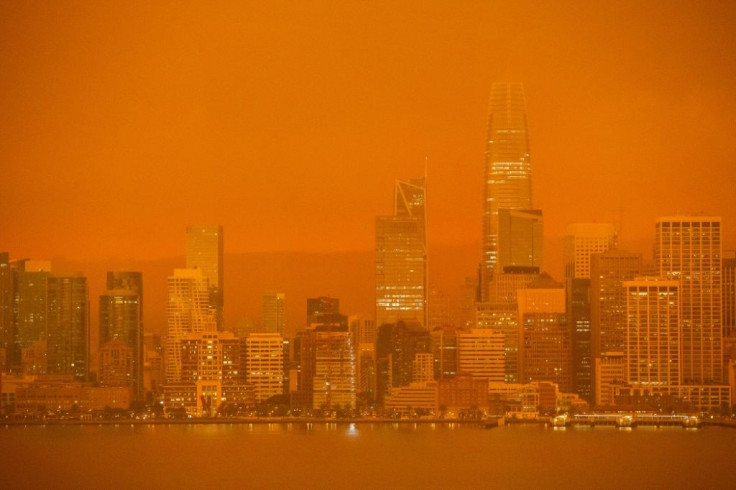 The San Francisco skyline is obscured in orange smoke and haze from the fires