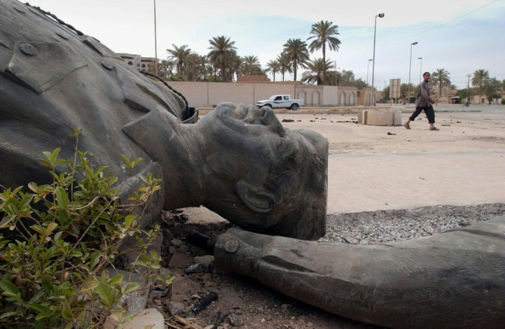 An Iraqi walks past a dismantled bronze statue of Iraqi dictator Saddam Hussein in Baghdad on April 13, 2003