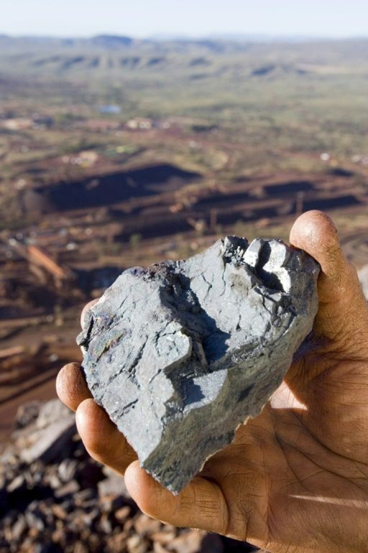 A worker holding a lump of high-grade iron ore from a Rio Tinto mine in Pilbara