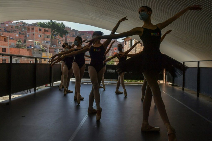 Wearing face masks, the dancers practice for four hours a day, five days a week