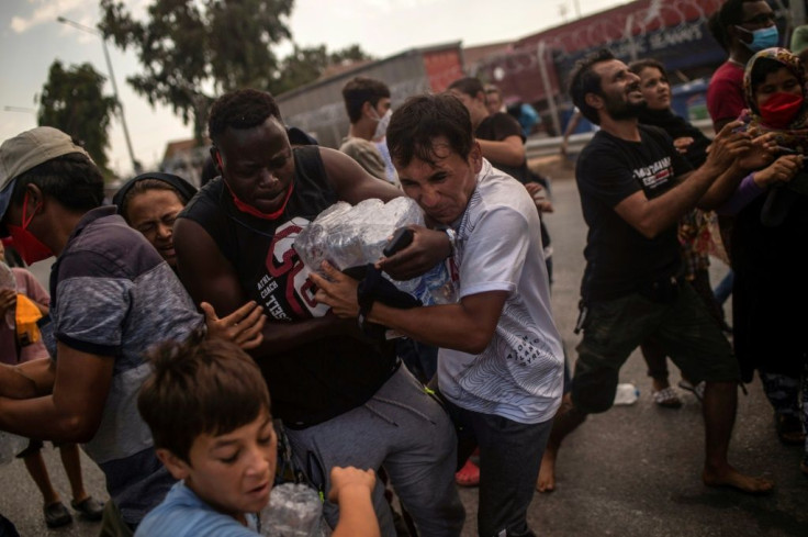 Homeless migrants and refugees fought for water bottles