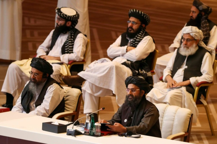 Taliban co-founder Mullah Abdul Ghani Baradar (R, bottom) speaks during the opening session of peace talks with the Afghan government