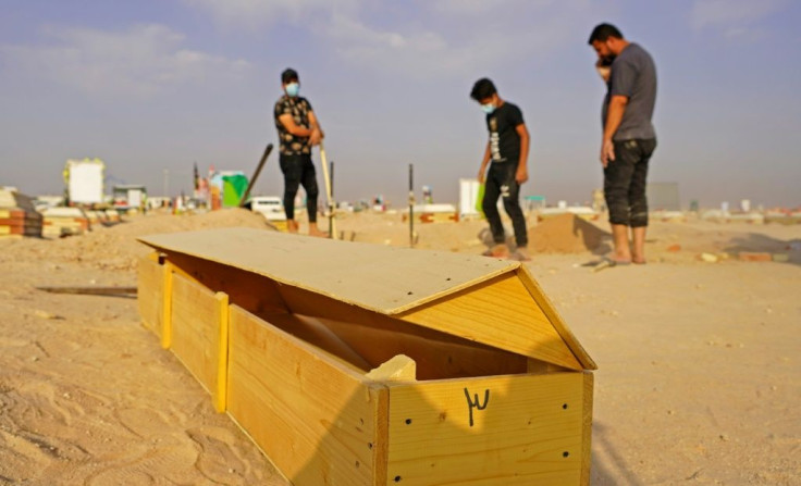 An Iraqi family digs up the corpse of a relative at a coronavirus cemetery in a plot of desert outside  Najaf to be transferred to a family cemetery for reburial