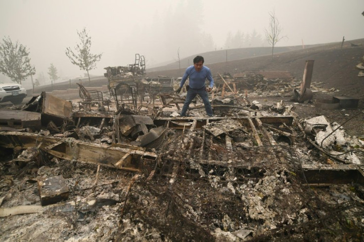 Marcelino Maceda searches his former mobile home for belongings unscathed by the fire