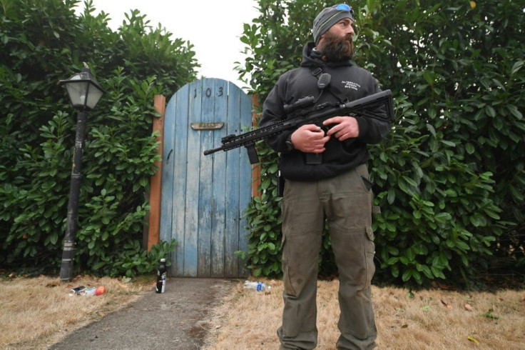 Matt Watts stands guard outside his house after the fire swept through