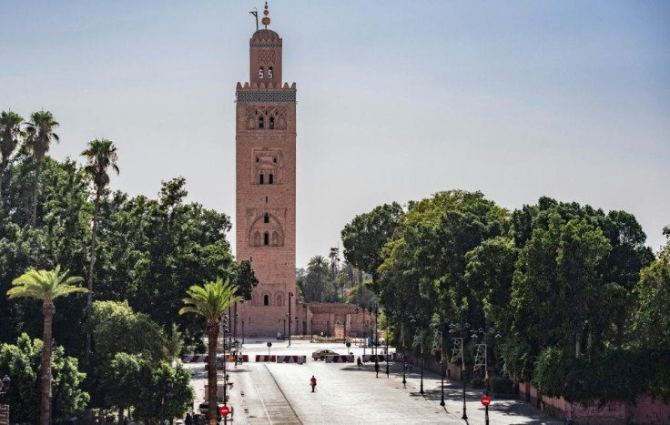 A few people walk by next to the Kutubiyya mosque's minaret tower at the Jemaa el-Fna square in the Moroccan city of Marrakesh on September 8, 2020, currently empty of its usual crowds due to the COVID-19 pandemic