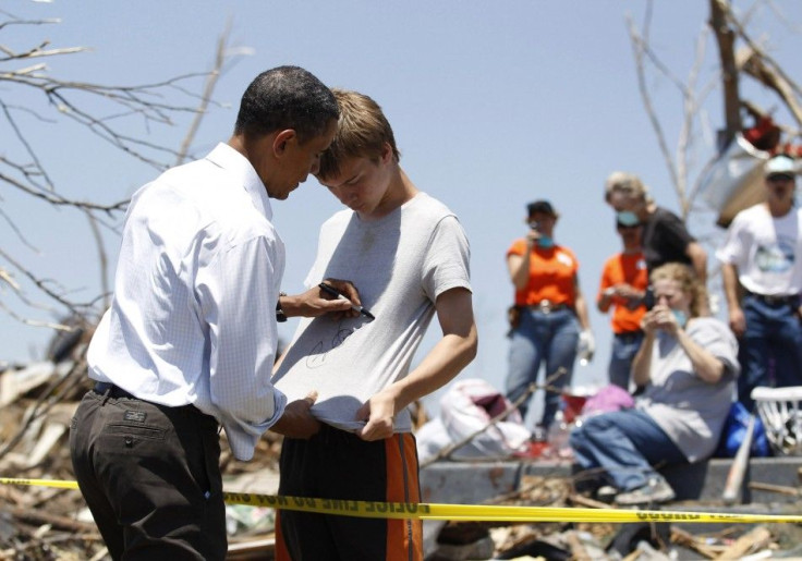 President Barack Obama autographs a boy's shirt