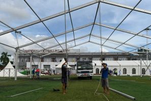 Workers building temporary shelters for coronavirus patients on a football pitch in Yangon, where new infections have spiked prompting opposition parties to call for a postponement of elections due in November